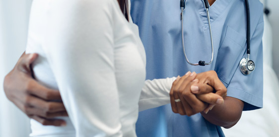 Medical professional holding patient's hand who is suffering from lupus