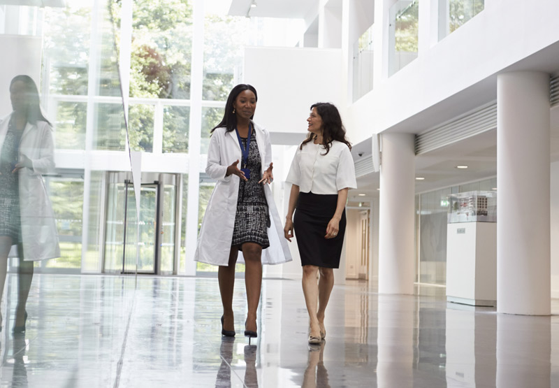 Two healthcare professionals talking in the hallway